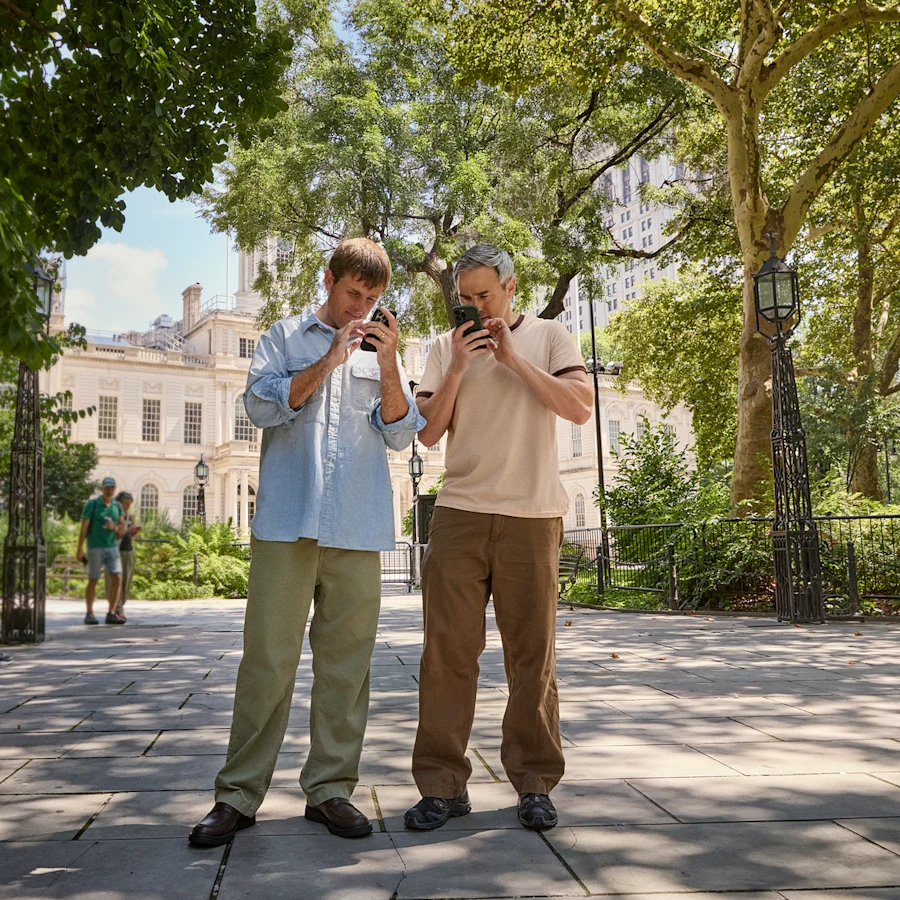 Bradford y Bryan Manning usan sus teléfonos en un parque.
